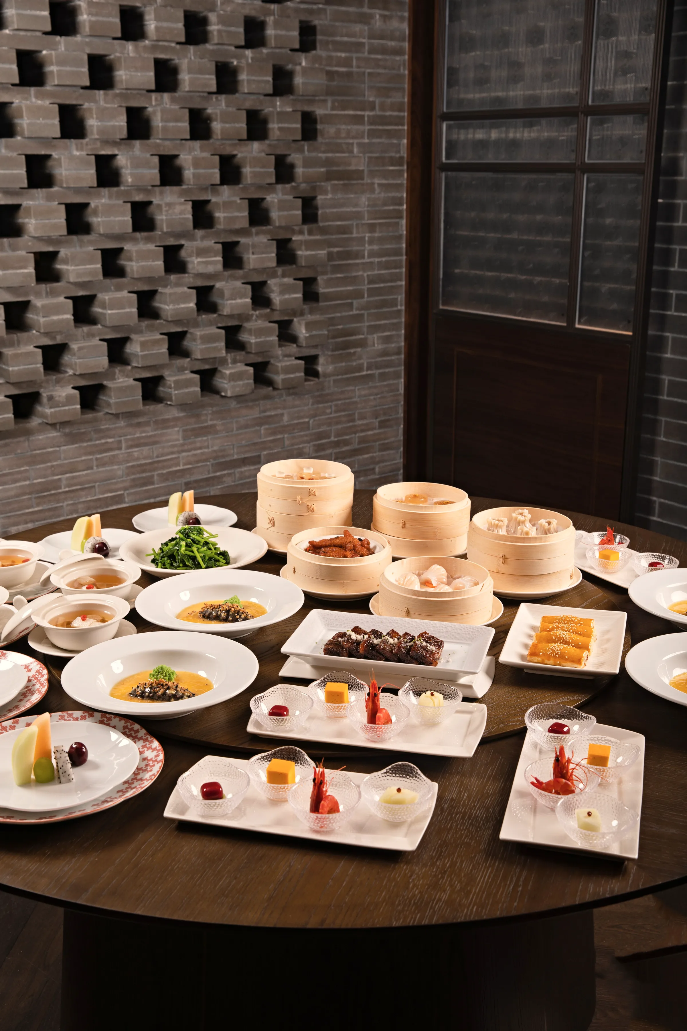 Small plates and steamer baskets set across a dark table