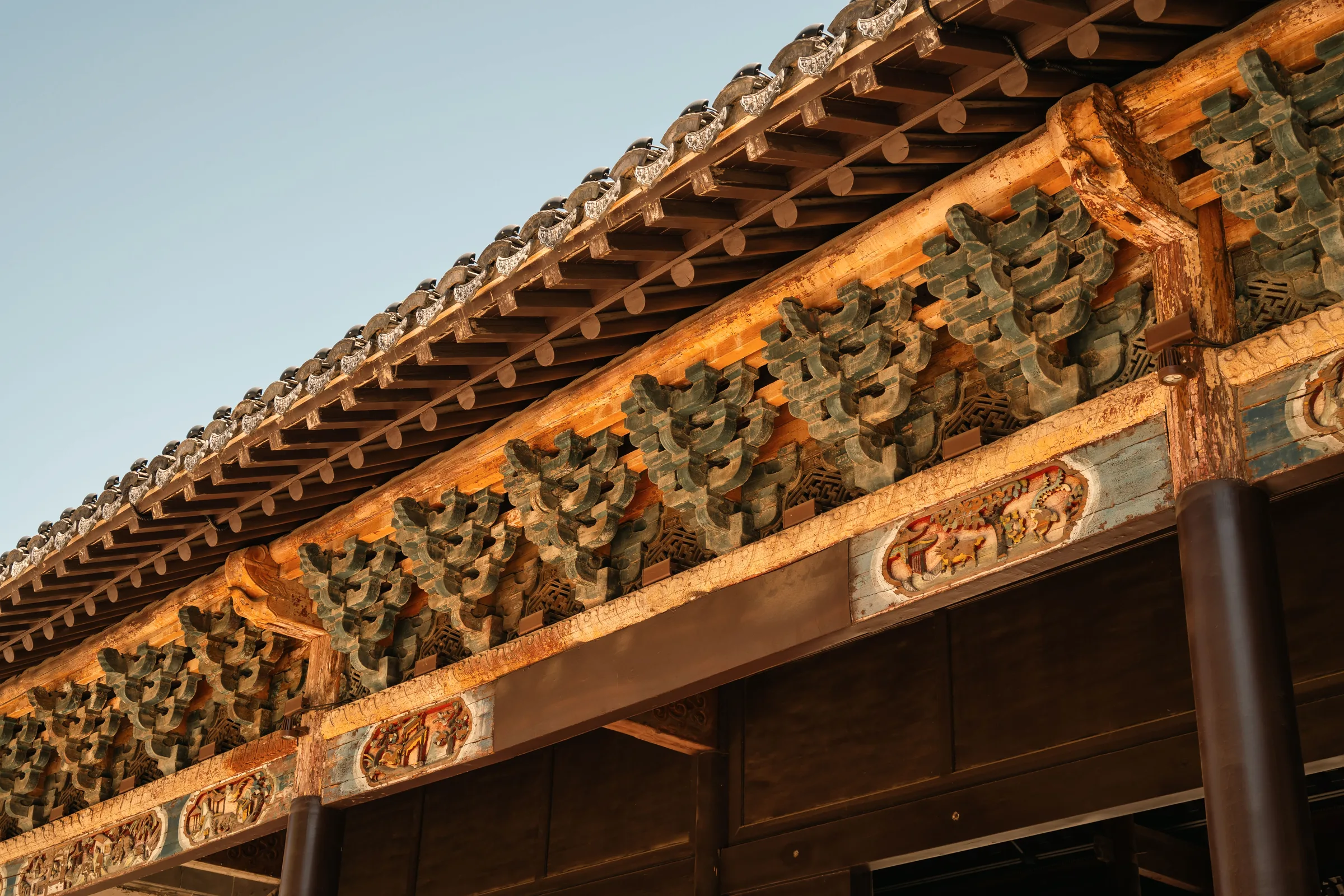 Carved timber eaves lit by late afternoon sun