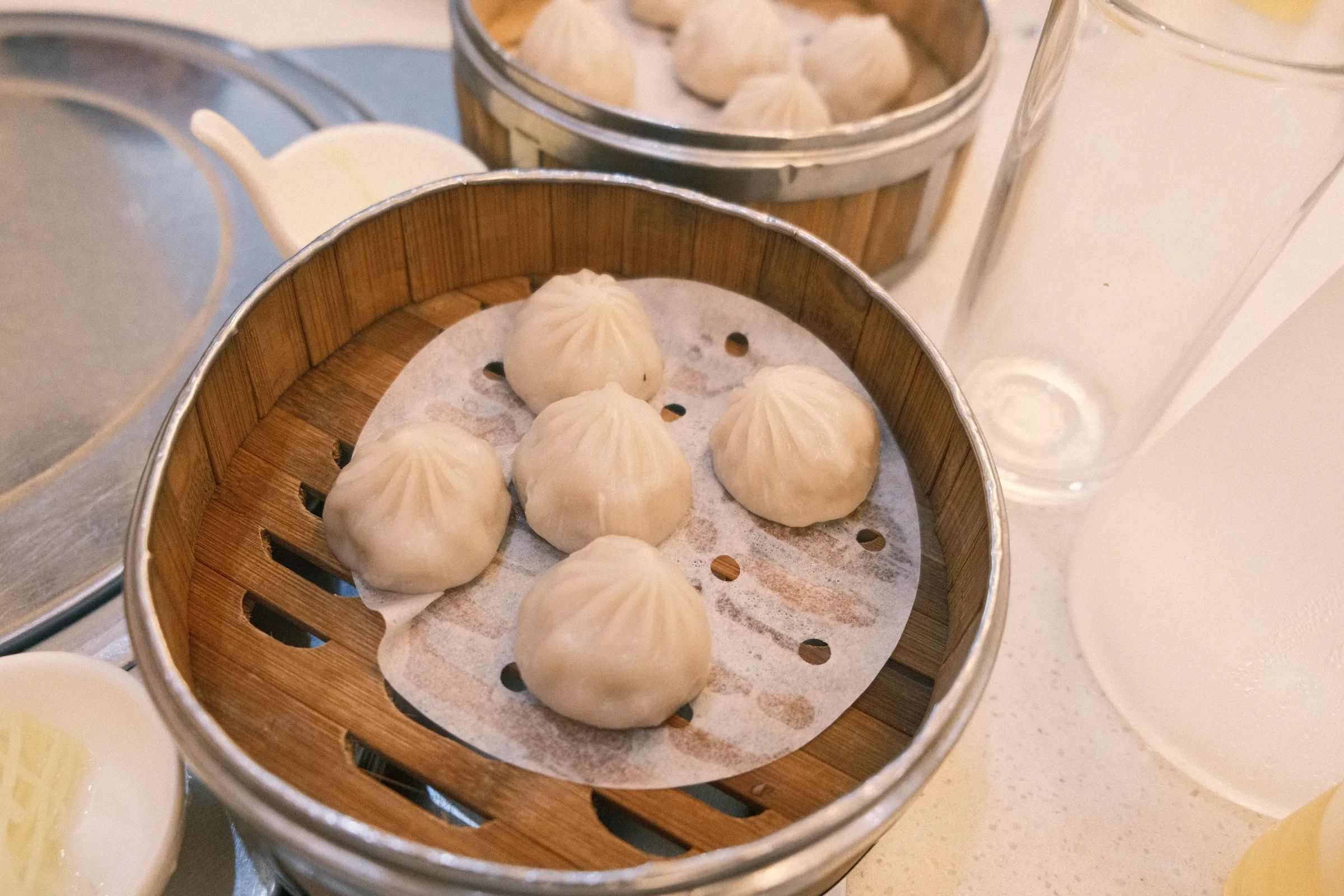 Bamboo steamers stacked beside a floured worktop